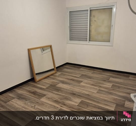 חדר ריק עם רצפת עץ, מראה וחלון